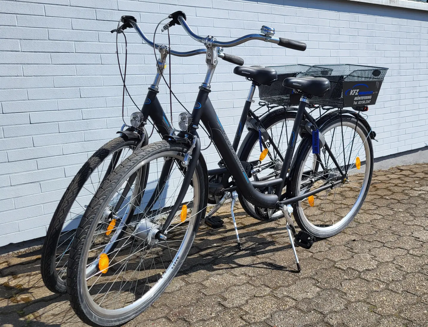 Foto: Übersicht unserer Leistungen Zwei Fahrräder mit Korb vor dem Werkstattgebäude